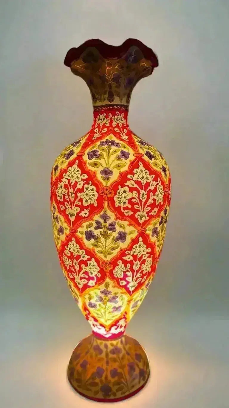 A glowing vase camel skin with fluted rim and intricate red yellow and purple floral patterns in handcrafted collection