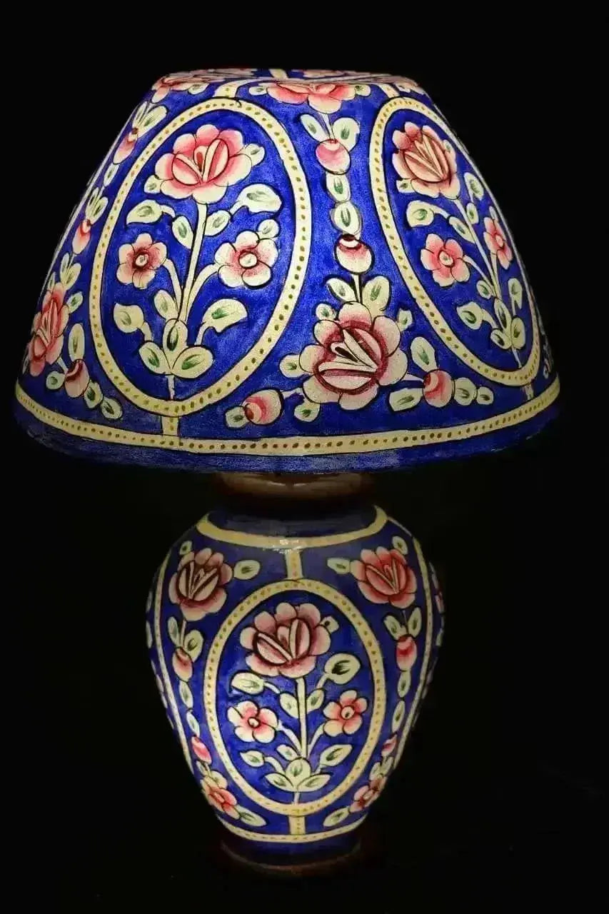 A vibrant blue table camel skin lamp with intricate pink cream floral patterns and gold detailing for unique home decor