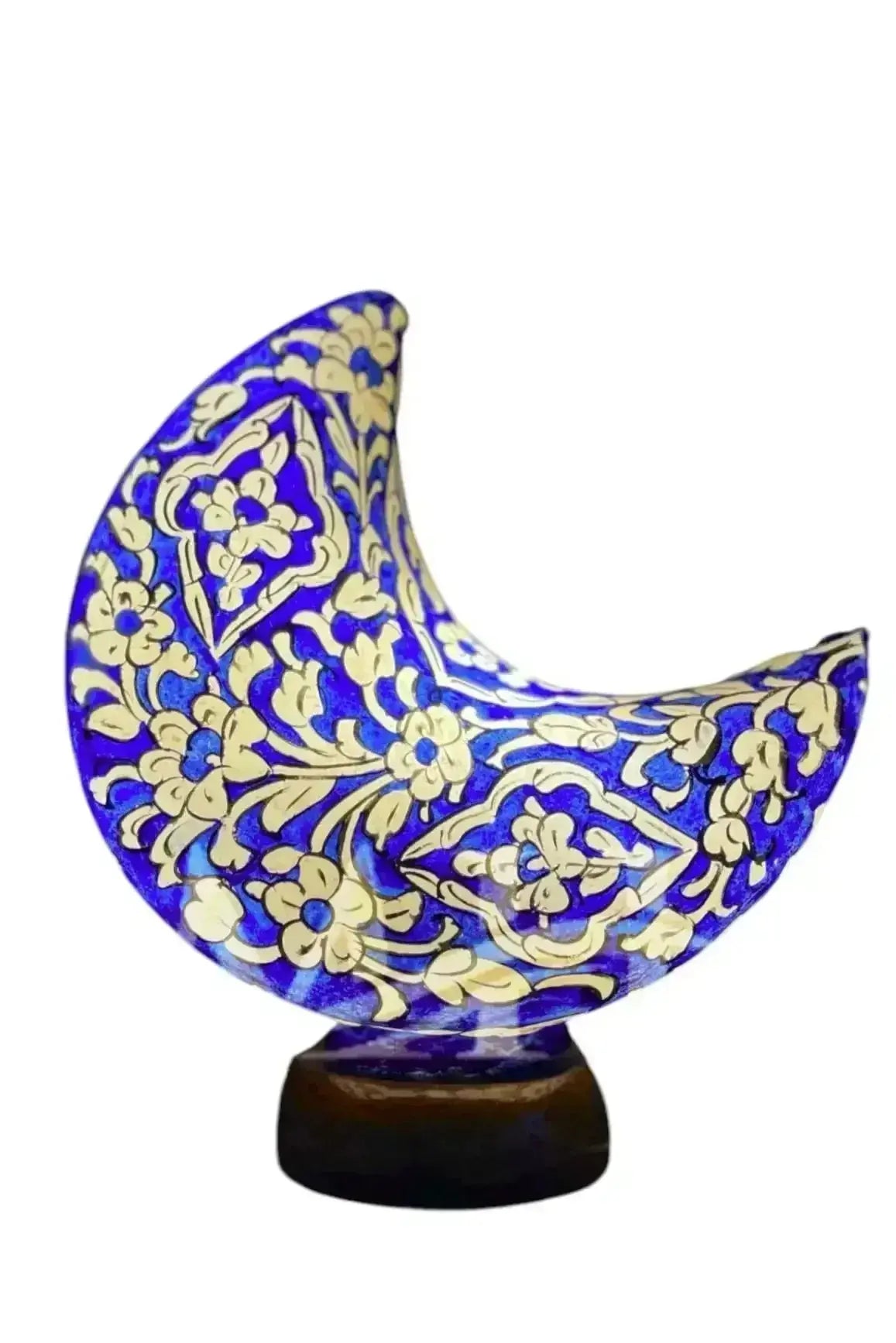 A vibrant cobalt blue ceramic moon shape camel ornament with gold floral patterns on a dark wooden base from the art moon shape collection